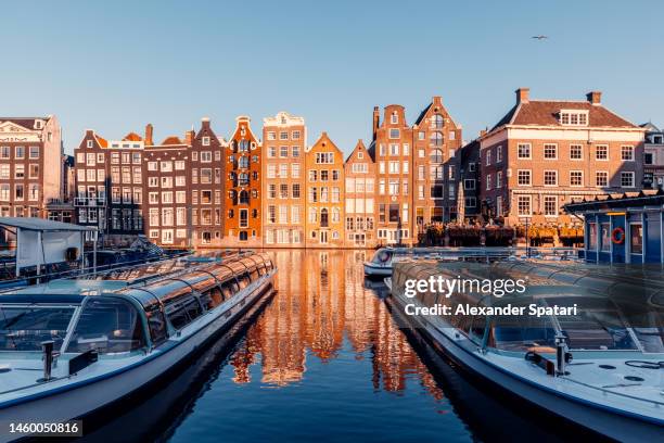 "dancing houses" on damrak canal in amsterdam, netherlands - amstel stockfoto's en -beelden