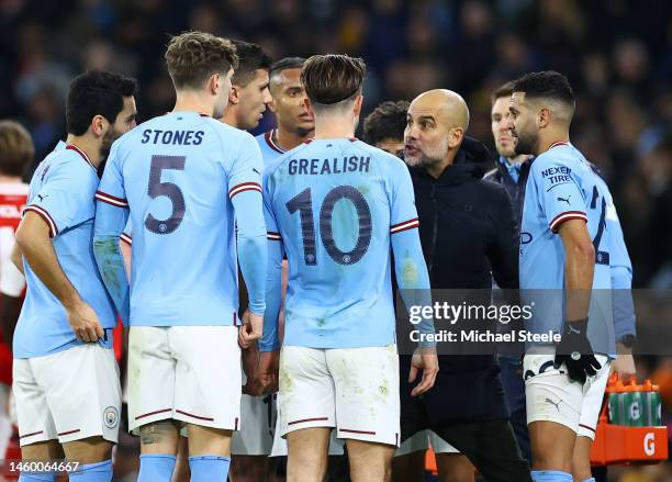 Pep Guardiola, Manager of Manchester City, speaks to their players during a break in play during the Emirates FA Cup Fourth Round match between...