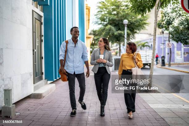 business coworkers having a conversation outdoors - walking street friends stock pictures, royalty-free photos & images