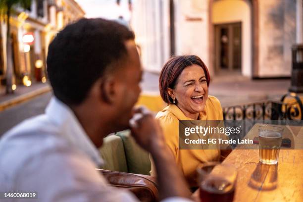 business coworkers talking and having a meeting at a restaurant - baby boomer millennial stock pictures, royalty-free photos & images