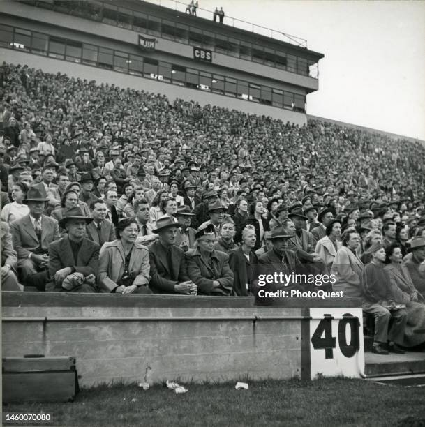 View of the crowded grandstand at Michigan State College during a college football game , East Lansing, Michigan, October 1950.