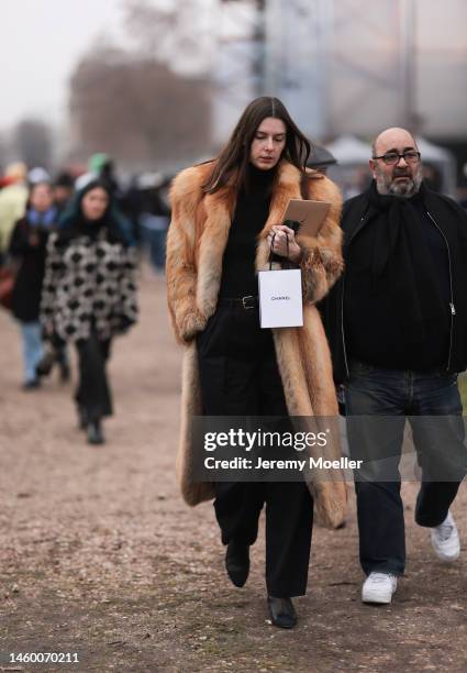 Fashion Week guest seen wearing black shirt, pants and boots and a brown fur coat, outside the Chanel Show, during Paris Fashion Week's Menswear...