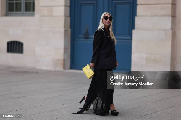 Corina Mihaila Larpin seen wearing black Peter Do jacket, yellow Hermes bag, black Yves Saint Laurent shoes, silver Stefere jewelry, black Linda...