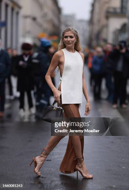 Lena Perminova seen wearing a dark brown Peekaboo bag by Fendi, a white shirt with cutouts, a brown skirt and matching heels before the Fendi show on...