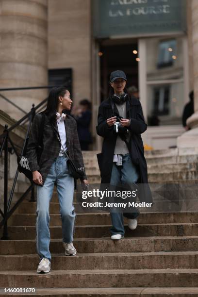 Fashion week guests seen wearing jeans and a blazer and a long coat before the Fendi show on January 26, 2023 in Paris, France.