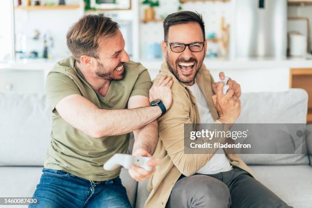 amis excités jouant aux jeux vidéo - manette de jeu vidéo photos et images de collection