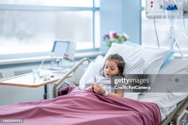 little girl eating a popsicle after surgery - girl in hospital bed sick stock pictures, royalty-free photos & images