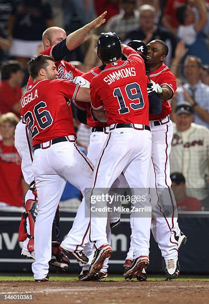 Jason Heyward of the Atlanta Braves is mobbed by teammates Dan Uggla, Michael Bourn, Brian McCann and Andrelton Simmons after Heyward scored the...