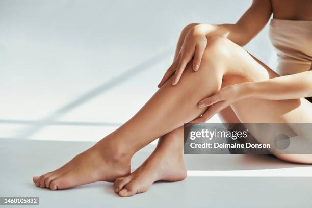 femme, jambes et beauté en studio pour la peau, le toilettage et le traitement d’hygiène sur fond gris. la jambe de fille et le mannequin se détendent après les soins de la peau, les cosmétiques et le luxe, se dorlotent et prennent soin de soi penda - femme pas sympa photos et images de collection