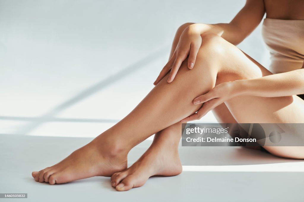 Woman, legs and beauty in studio for skin, grooming and hygiene treatment against grey a background. Girl leg and model relax after skincare, cosmetics and luxury, pamper and self care while isolated