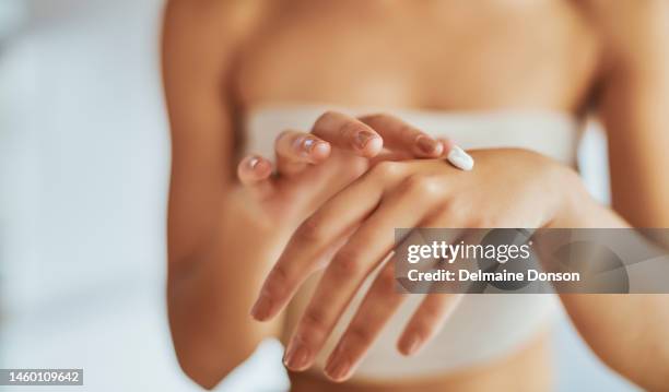 hands, skincare and moisturizer with a woman in studio to apply antiaging cosmetics to her skin for wellness. manicure, beauty and lotion with a female applying a natural treatment to her hand - beauty studio moisturisers stock pictures, royalty-free photos & images