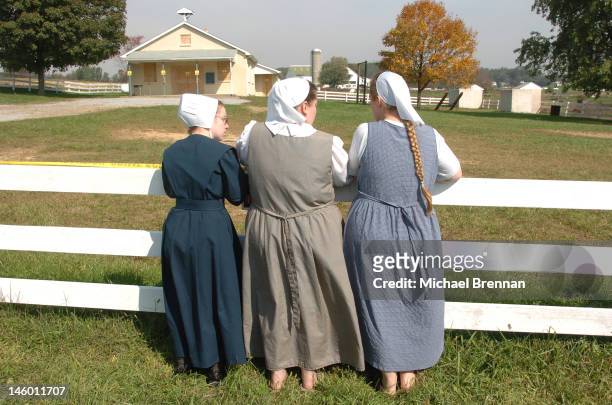Three Amish women pray outside the schoolhouse in Nickel Mines, Pennsylvania, where several schoolchildren were recently murdered, 5th October 2006....