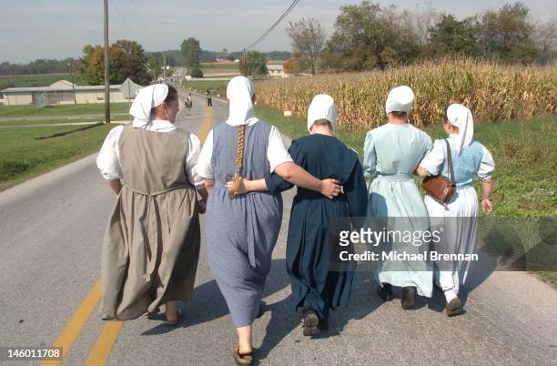 Five Amish women on their way to pray outside the schoolhouse in Nickel Mines, Pennsylvania, where several schoolchildren were recently murdered, 5th...