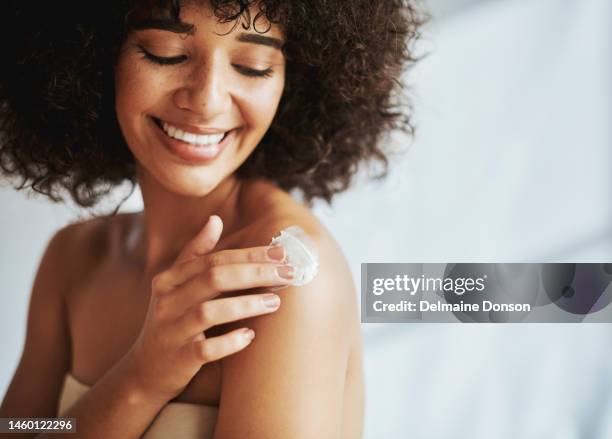 femme noire, crème et peau avec sourire, épaules et soins personnels, commencez et matinée à la maison. femme, produit et peau pour les cosmétiques, éclat sain et esthétique naturelle pour l’amour de soi, la santé ou la beauté - lounge chair photos et images de collection