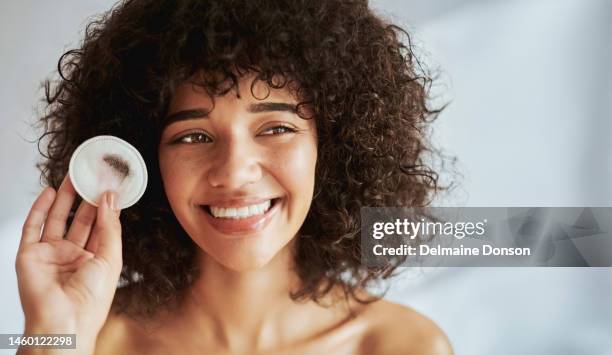 black woman, skincare cotton pad and morning with smile, dirt or makeup for beauty, self care and cosmetics. woman, cleaning skin and foundation for aesthetic, exfoliating and natural glow on face - model smile stockfoto's en -beelden