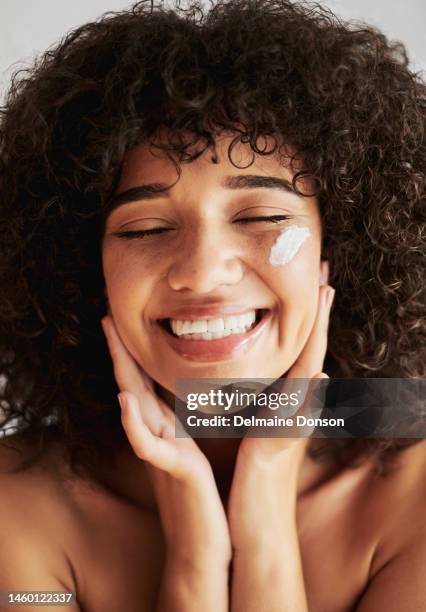 crème, visage et femme noire avec crème solaire, produits cosmétiques et publicité beauté. heureux, amoureux de soi ou modèle de soins de la peau avec sourire pour la lotion, l’huile essentielle ou la crème hydratante pour le visage - applying stock photos et images de collection