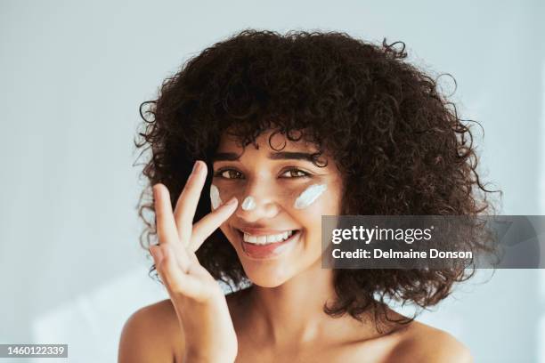 cream, moisturizer and face, skincare woman in beauty or collagen promotion on white wall background. facial, cosmetics and portrait of young and happy person or model with lotion or sunscreen - happy faces stockfoto's en -beelden