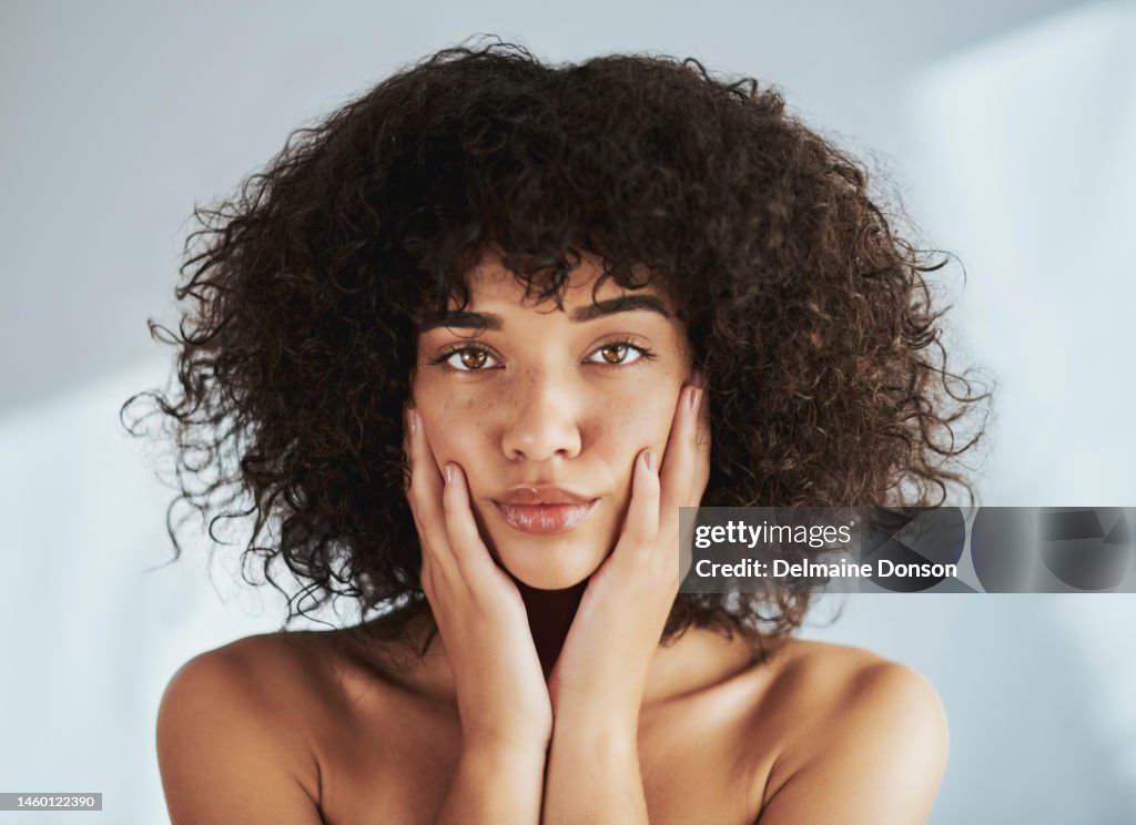 Portrait, beauty and facial with a black woman in studio to promote natural skincare or treatment. Face, skin and wellness with an attractive young female touching her cheeks for dermatology