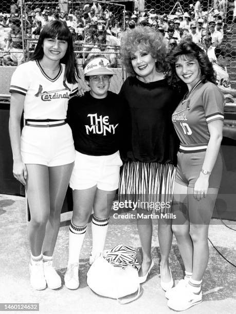 Joshua Mills and American comedienne, actress, singer and businesswoman, Edie Adams pose for a portrait with two unidentified St. Louis Cardinals...