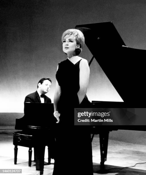 German American pianist, composer, and conductor André Previn , plays his piano as American comedienne, actress, singer and businesswoman, Edie Adams...