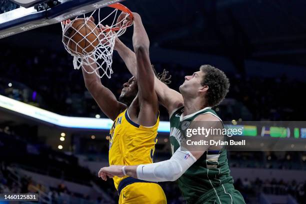 Myles Turner of the Indiana Pacers dunks the ball past Brook Lopez of the Milwaukee Bucks in the fourth quarter at Gainbridge Fieldhouse on January...