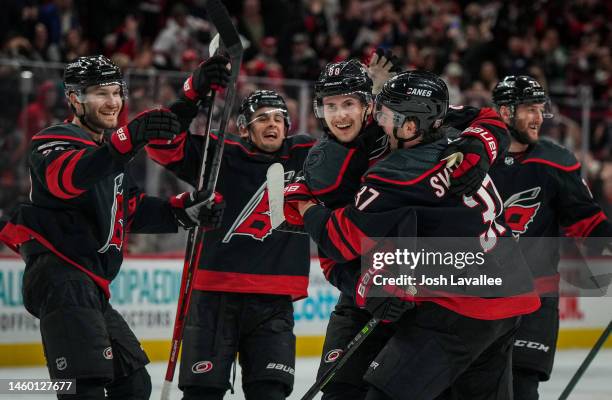 Martin Necas of the Carolina Hurricanes celebrates with teammates after scoring the game-winning goal in overtime to defeat the San Jose Sharks at...