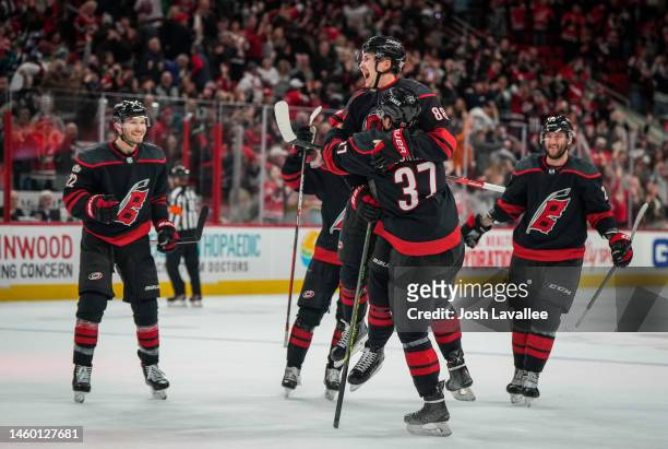 Martin Necas of the Carolina Hurricanes celebrates with teammates after scoring the game-winning goal in overtime to defeat the San Jose Sharks at...