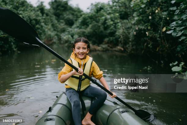 cheerful young girl enjoying river kayaking - girl rowing boat photos et images de collection