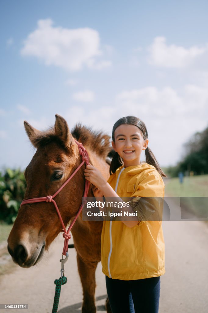Young girl with native Japanese horse (Yonaguni pony)