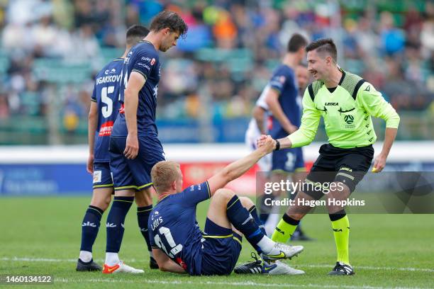Referee Lachlan Keevers helps Joshua Laws of the Phoenix to his feet during the round 14 A-League Men's match between Wellington Phoenix and Perth...