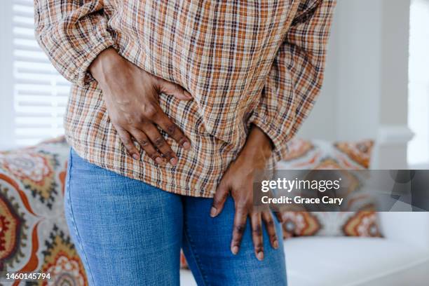 woman holds her abdomen in pain - fibroids 個照片及圖片檔