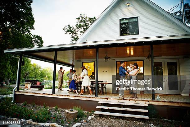 family on porch after dinner at twilight - share house stock pictures, royalty-free photos & images