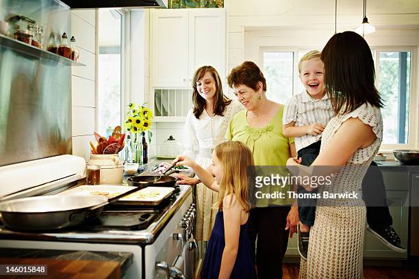 three generations cooking together in home kitchen - texas family stock pictures, royalty-free photos & images