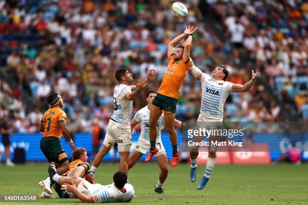 Josh Turner of Australia competes for the ball against German Schulz and Luciano Gonzalez of Argentina during the 2023 Sydney Sevens match between...