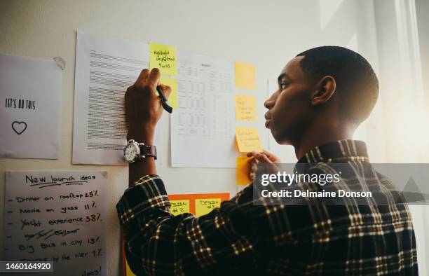 thinking, writing and black man brainstorming on wall with mindmap and planning schedule and ideas on notes. strategy, goals and business idea on moodboard and creative man with vision for project. - business strategy map stock pictures, royalty-free photos & images