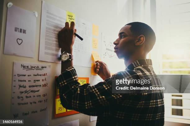 business, plan and black man brainstorming on wall with mindmap and planning schedule and writing notes. strategy, goals and ideas on moodboard and creative man with vision working on startup project - content stock pictures, royalty-free photos & images