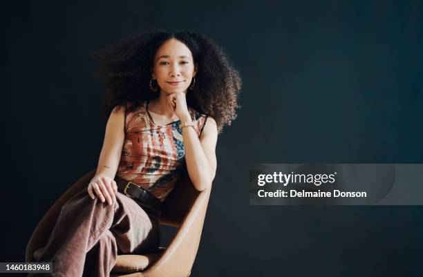 chair, trendy and beautiful black woman isolated on dark background for success, creative vision and mock up space. confident, attitude and smart person portrait for female empowerment on wall mockup - ms foundation women of vision awards stockfoto's en -beelden