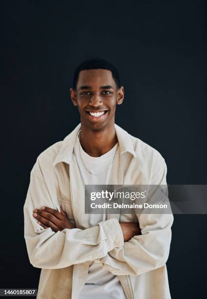 portrait, black man and arms crossed with smile, leadership and casual outfit on studio background. african american male, young person and guy with positive mindset, happiness and trendy on backdrop - portraits studio smile stockfoto's en -beelden