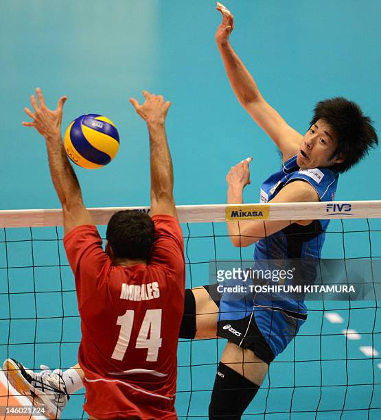 Japan's Yuta Yoneyama spikes the ball past Puerto Rico's Fernando Morales during their men's volleyball qualifying tournament match for the London...