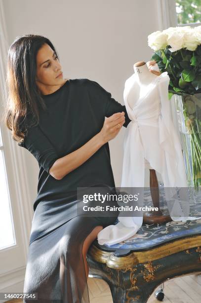 Designer Estrella Archs fitting a tiny dressmaker mannequin with sample of a white chiffon dress at the Ungaro atelier in preparation for the Spring...