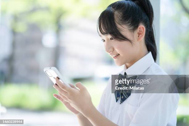 student looking at smartphone at bus stop - ssc exam stock pictures, royalty-free photos & images