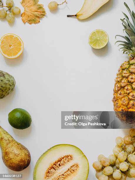 various fresh fruits frame - lime, grape, pinapple, melon, pears, apple on white background - apple white background stock-fotos und bilder