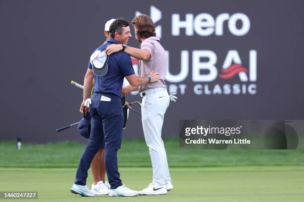 Rory McIlroy of Northern Ireland and Tommy Fleetwood of England interact on the 18th green during the continuation of Round Two on Day Three of the...