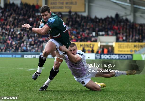 Freddie Burns of Leicester Tigers is held by Ollie Sleightholme during the Gallagher Premiership Rugby match between Leicester Tigers and Northampton...