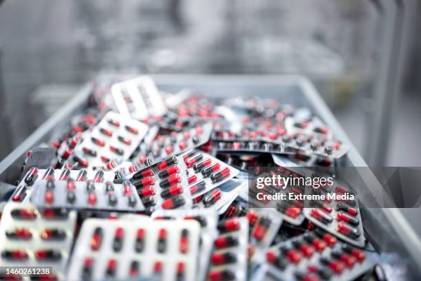 pharmaceutical manufacturing - a container filled with blister-packaged capsules - blister pack stock pictures, royalty-free photos & images