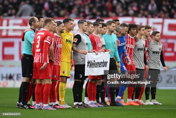 Freiburg and FC Augsburg players line up with match officials with a #WeRemember campaign sign, to honour the 78th anniversary of Auschwitz...