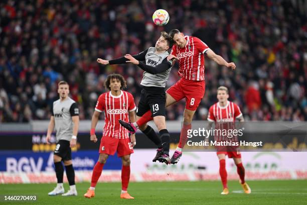 Elvis Rexhbecaj of FC Augsburg jumps for the ball with Maximilian Eggestein of SC Freiburg during the Bundesliga match between Sport-Club Freiburg...