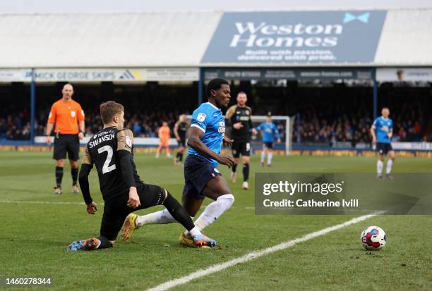 Zak Swanson of Portsmouth fouls Ephron Mason-Clark of Peterborough United leading to a penalty which is scored by Jonson Clarke-Harris of...