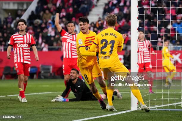 Pedri of FC Barcelona celebrates after scoring the team's first goal with teammate Frenkie de Jong as Paulo Gazzaniga of Girona FC reacts during the...