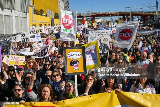 Teachers hold protest signs as they march from the Ministry of Education to Belem Presidential Palace to protest for better working conditions during...